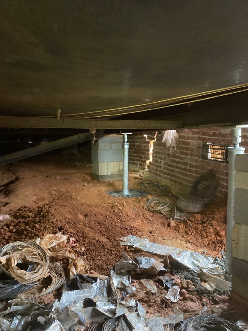 HydroHelp911 Crawl Space & Foundation Repair installing adjustable steel jacks to support a sagging crawl space floor.