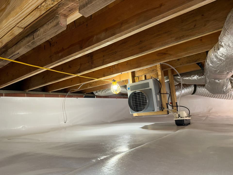 HydroHelp911 Crawl Space & Foundation Repair installing a dehumidifier and vapor barrier in a crawl space.