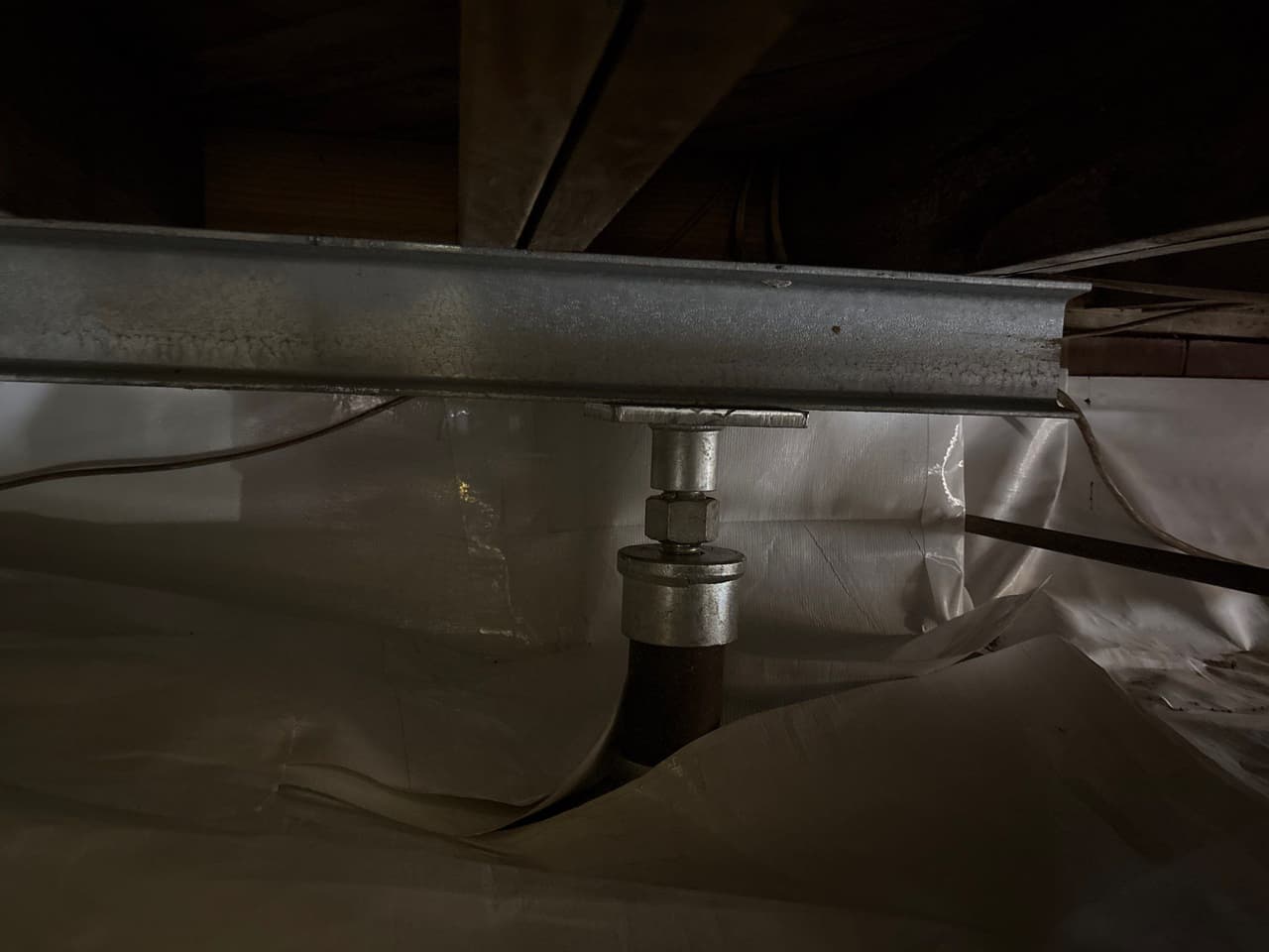 HydroHelp911 Crawl Space & Foundation Repair installing crawl space support jacks and a steel beam for structural stability.