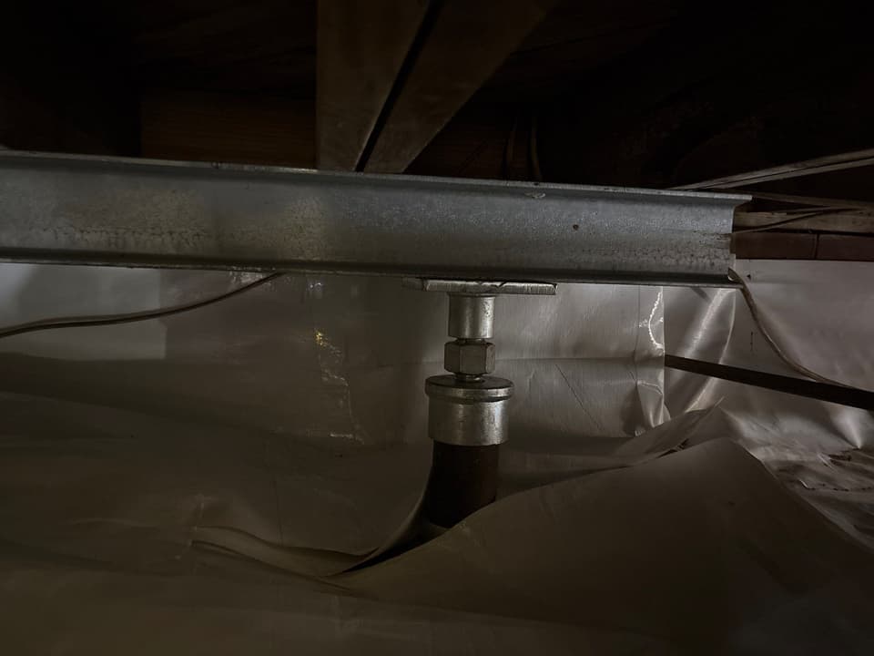 HydroHelp911 Crawl Space & Foundation Repair installing crawl space support jacks and a steel beam for structural stability.