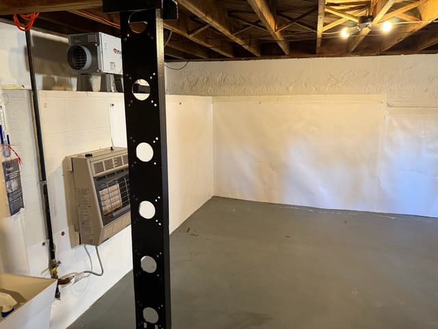 HydroHelp911 Crawl Space & Foundation Repair installing a vapor barrier and dehumidifier in a basement.
