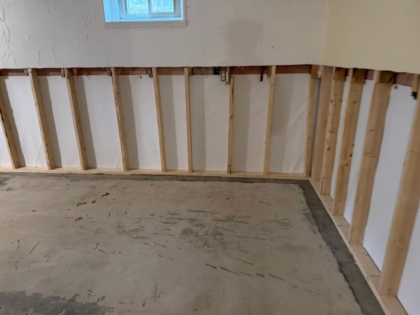 HydroHelp911 Crawl Space & Foundation Repair performing interior basement waterproofing with framing, a vapor barrier