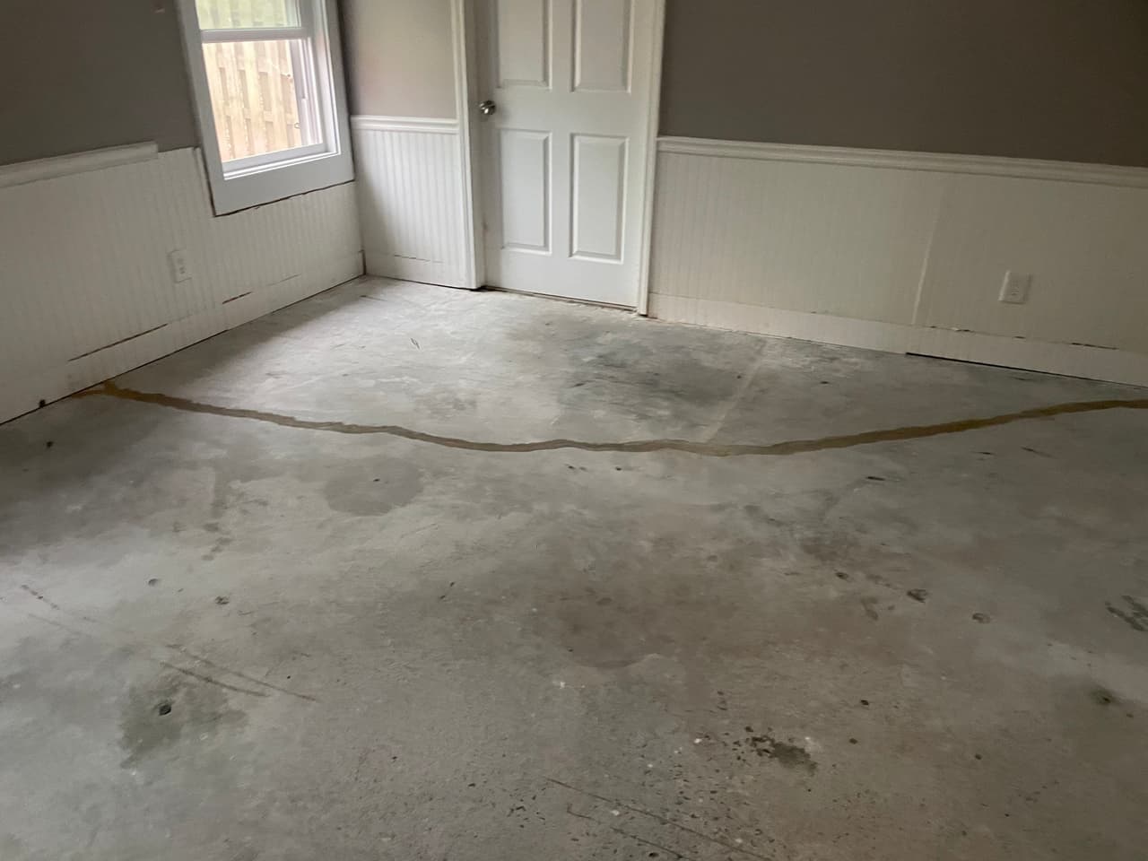 HydroHelp911 Crawl Space & Foundation Repair crew sealing a concrete floor crack with polyurethane crack sealer.