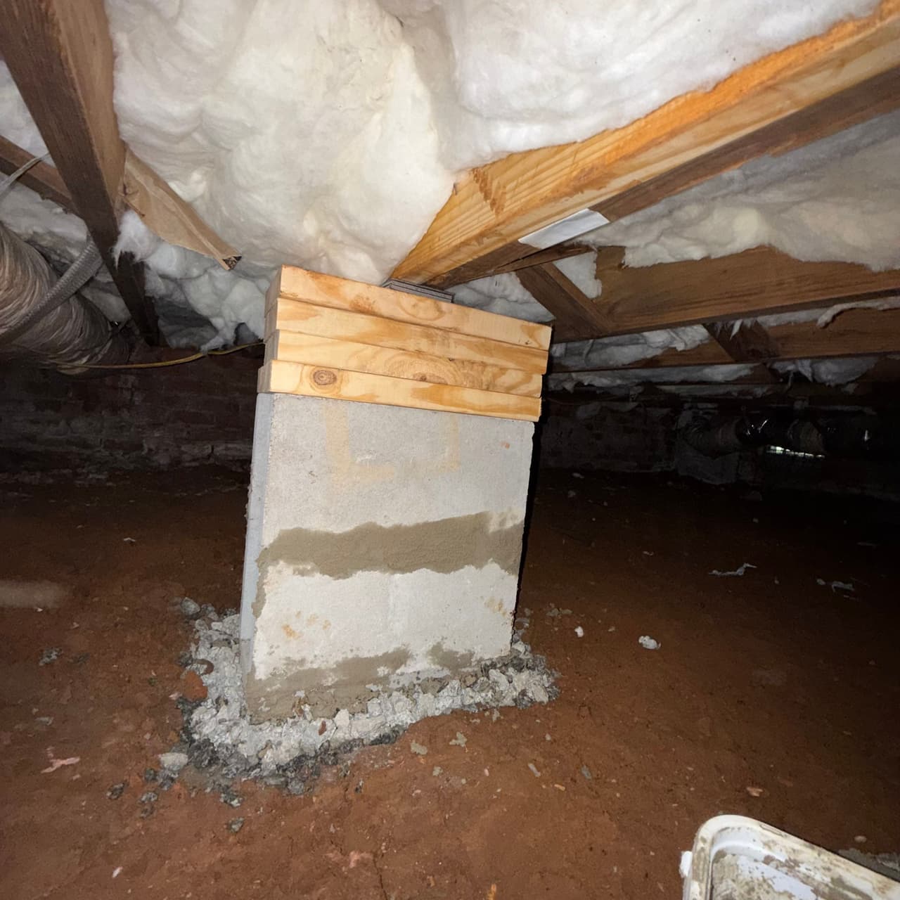 HydroHelp911 Crawl Space & Foundation Repair adjusting a block pier with wood shims as part of a pier and beam repair.