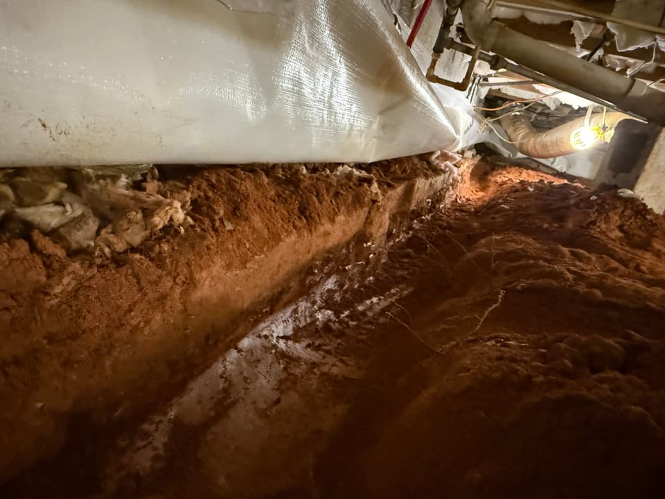 HydroHelp911 Crawl Space & Foundation Repair installing a vapor barrier and interior drainage system in a crawl space.