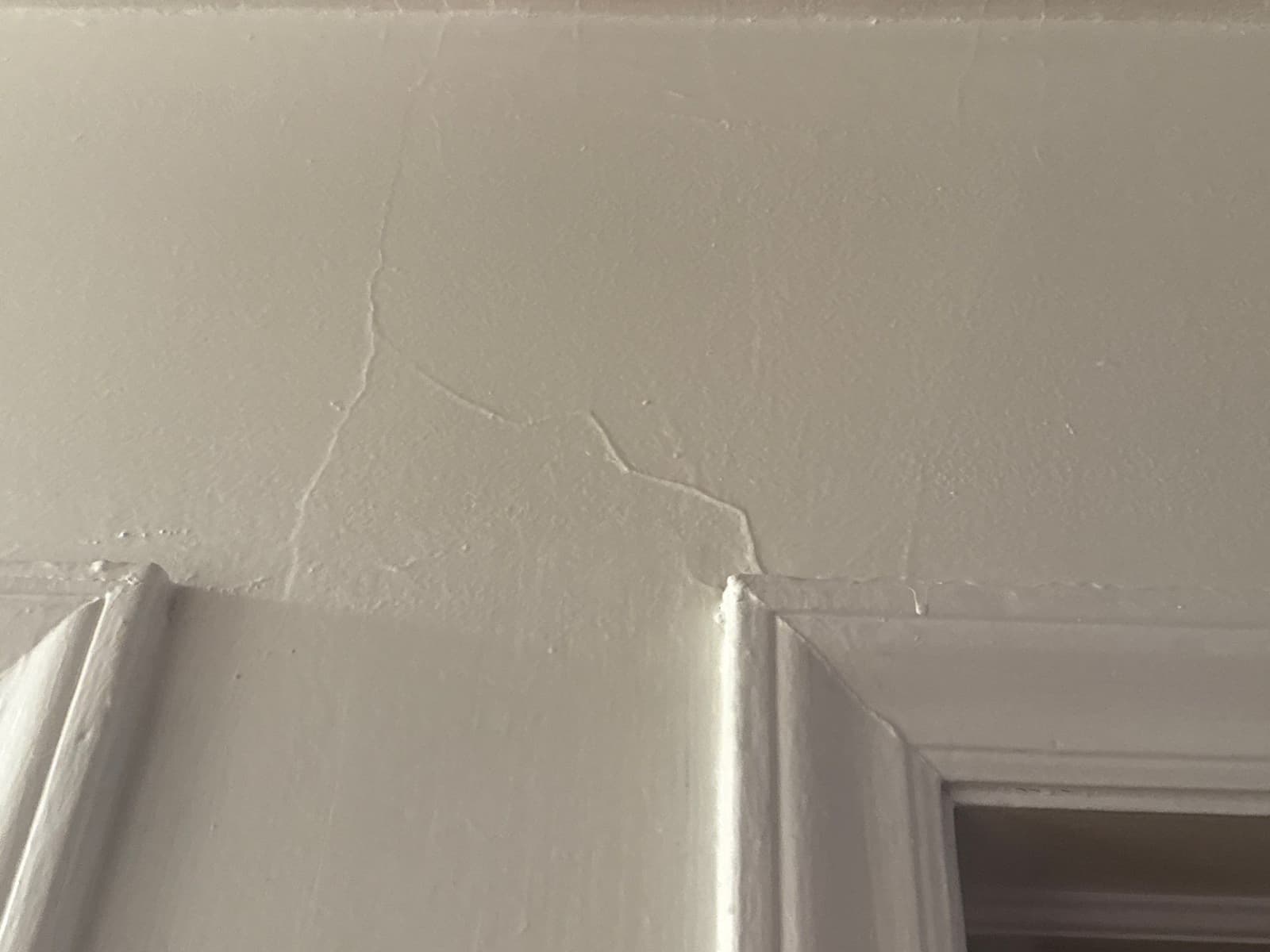 HydroHelp911 Crawl Space & Foundation Repair inspecting drywall cracks around an interior door frame