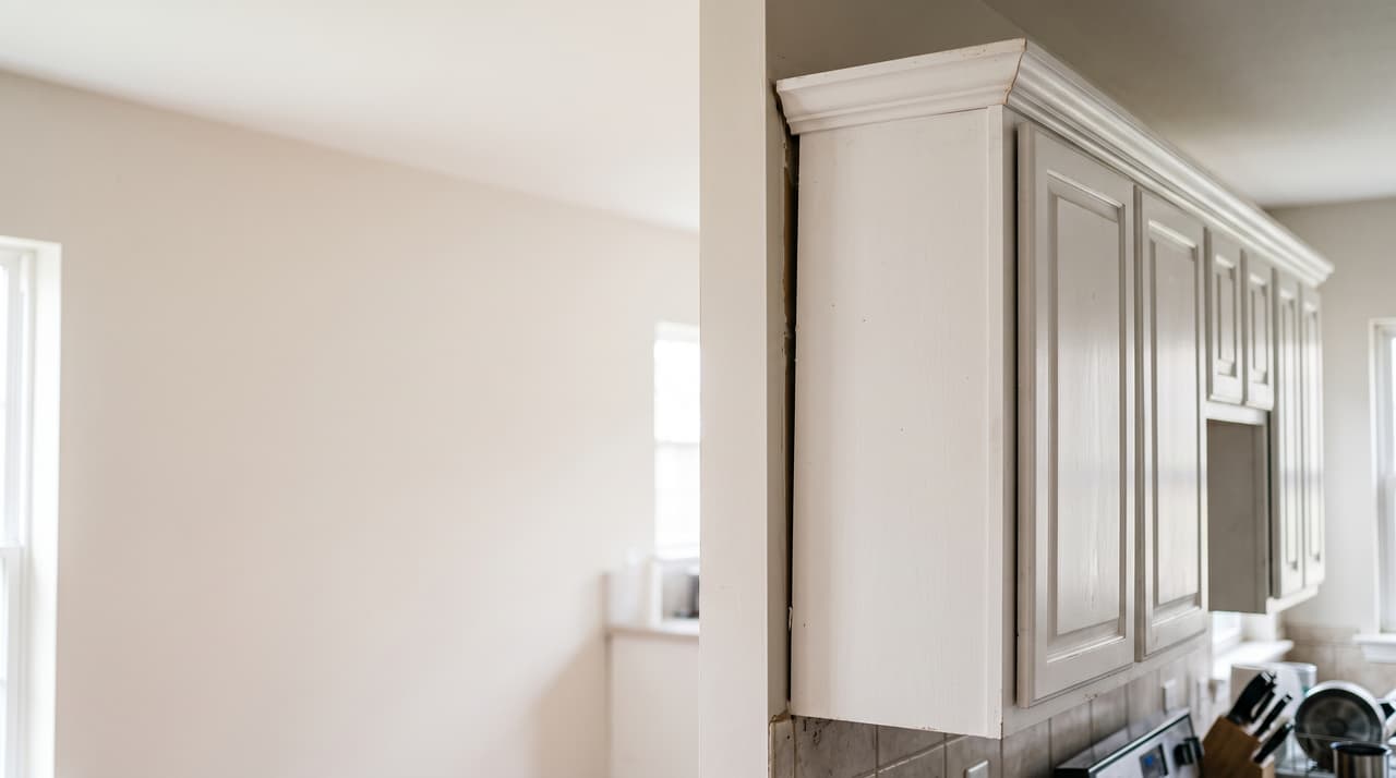 Inspecting detached kitchen cabinets due to foundation issues.