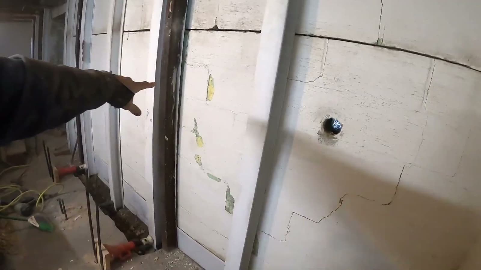 HydroHelp911 Crawl Space & Foundation Repair technician inspecting a bowing basement wall with cracks.