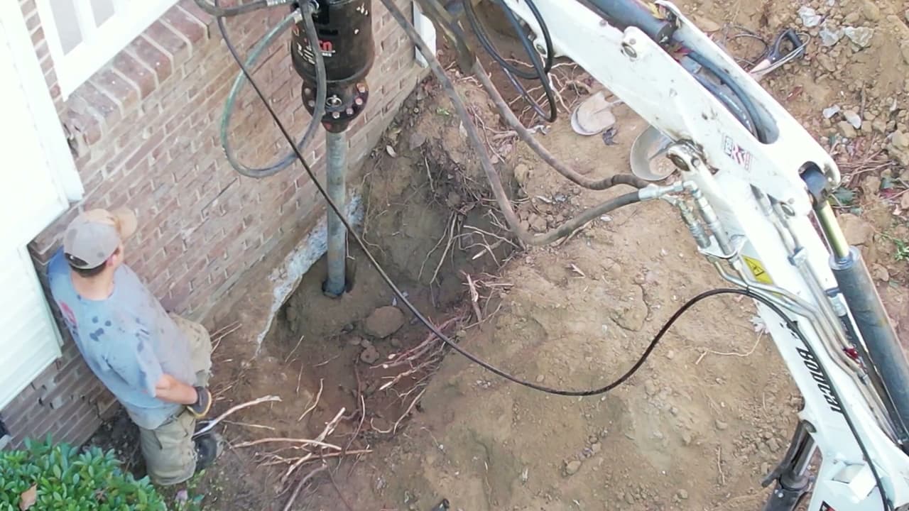 Installing steel helical piers for foundation underpinning