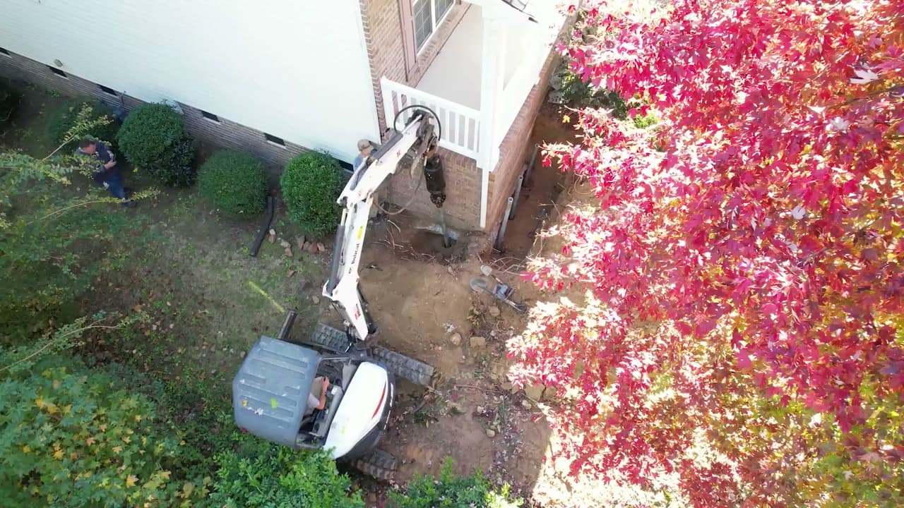 Installing helical piers with a mini excavator and rotary drive head.
