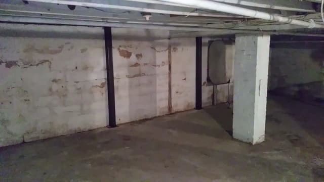HydroHelp911 Crawl Space & Foundation Repair installing steel I-beam wall bracing in a basement to stabilize cracked walls.