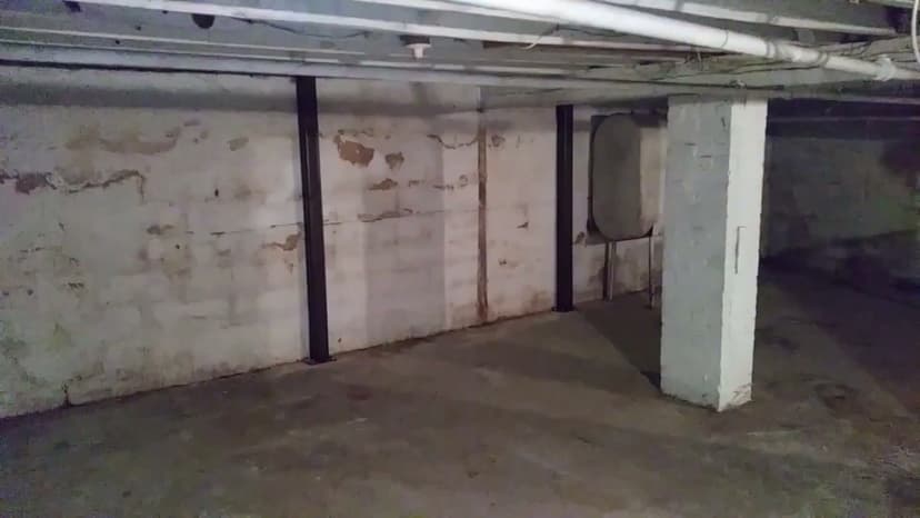 HydroHelp911 Crawl Space & Foundation Repair installing steel I-beam wall bracing in a basement to stabilize cracked walls.