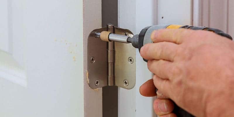 Hand tightening a door hinge screw with a power drill