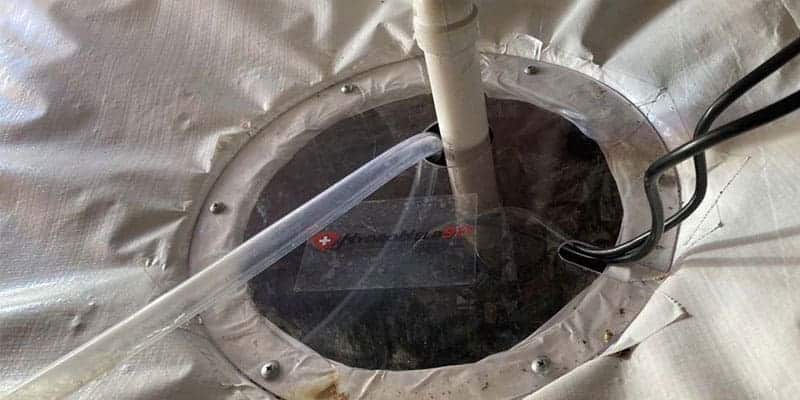 Sump pit with a discharge pipe sealed into a crawl space liner