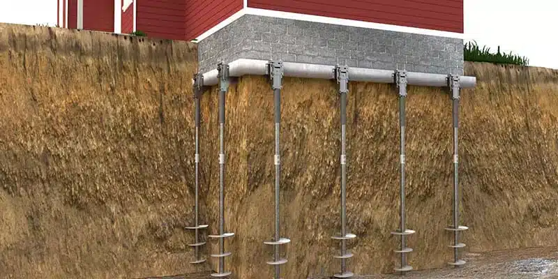 Illustration of helical piers supporting a house foundation