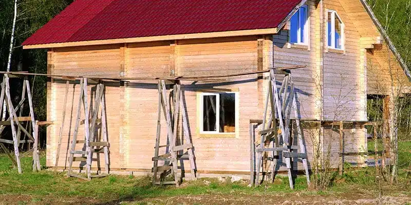 Wood frame house with scaffolding along its walls