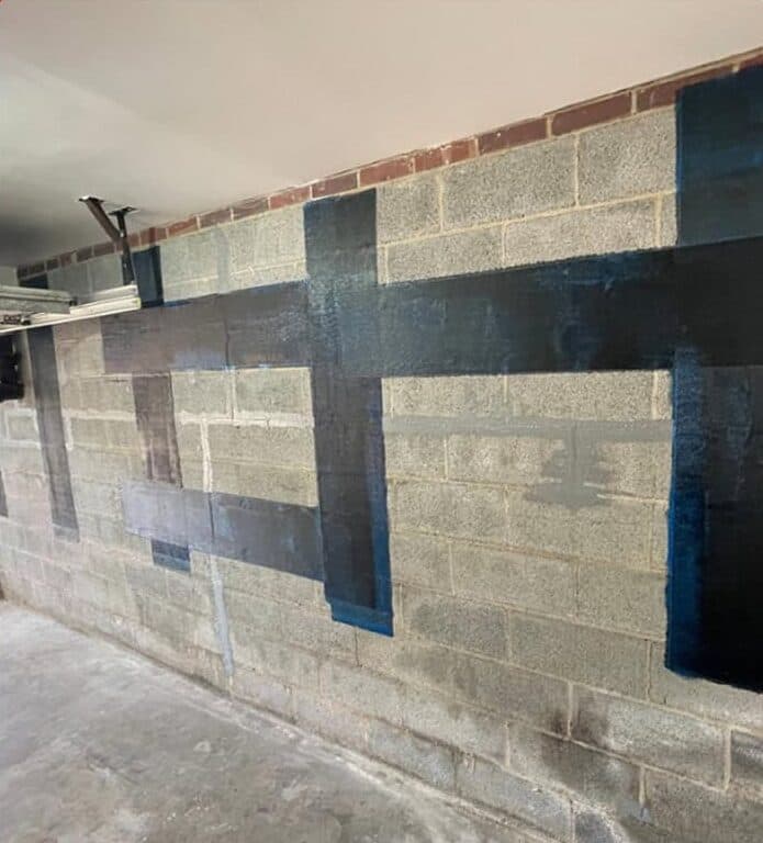 Carbon fiber straps bonded to a concrete block basement wall
