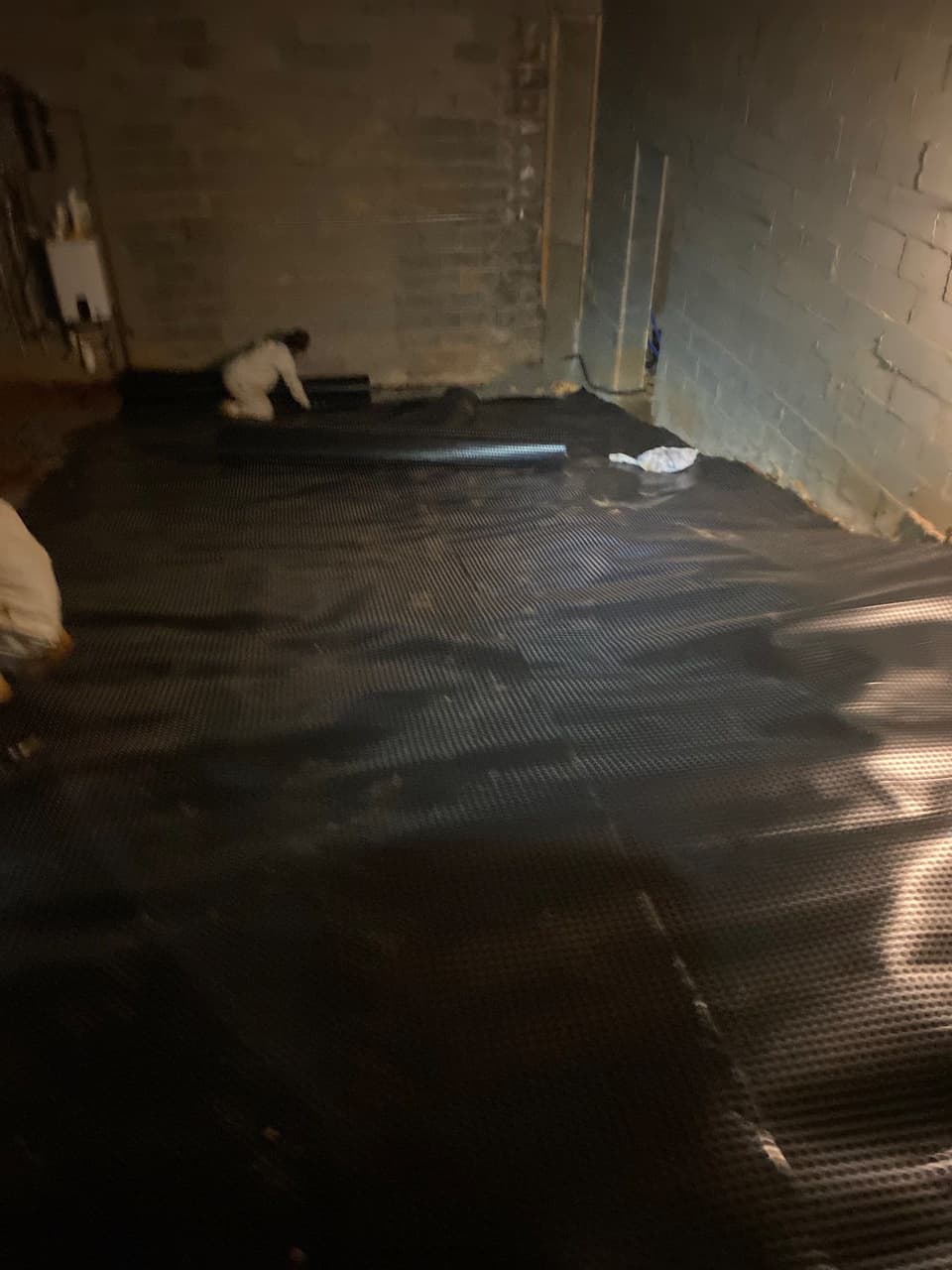 HydroHelp911 Crawl Space & Foundation Repair installing interior drainage matting on a crawl space floor.
