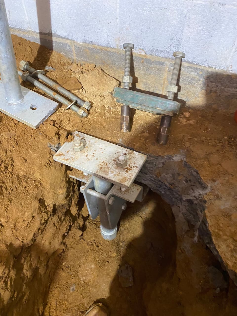 HydroHelp911 Crawl Space & Foundation Repair installing steel pier foundation underpinning for a block foundation.