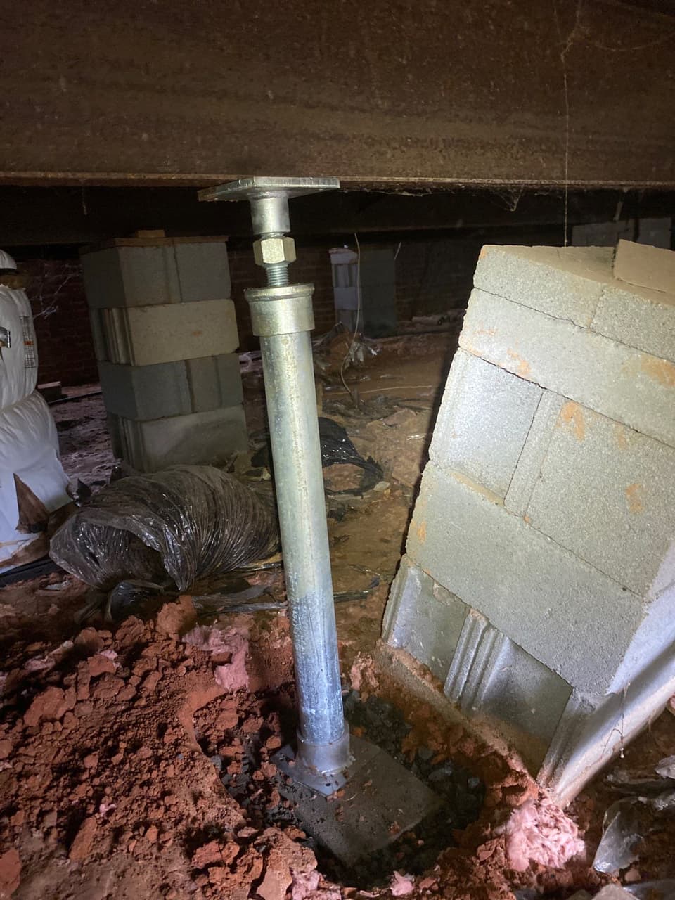 HydroHelp911 Crawl Space & Foundation Repair installing an adjustable crawl space jack to support a floor joist.