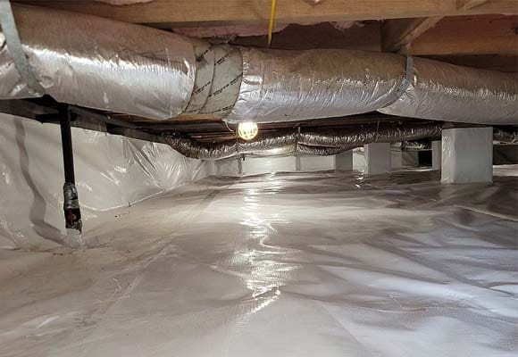 Encapsulated crawl space with a white liner and insulated ducts in Hudson, NC