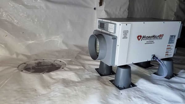 HydroHelp911 dehumidifier on stands in an encapsulated crawl space